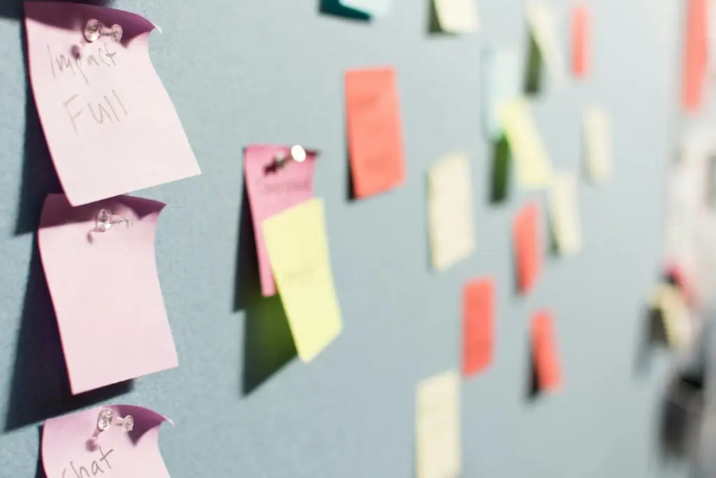 Post-it lappar i olika färger på tavla